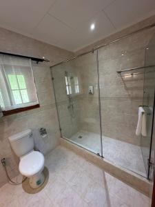 a bathroom with a toilet and a glass shower at Benjamine's Guesthouse in La Digue