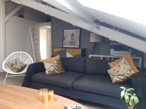 uma sala de estar com um sofá azul e uma mesa em Le DUPLEX de Boulogne/Roland Garros/1 à 4 personnes em Boulogne-Billancourt