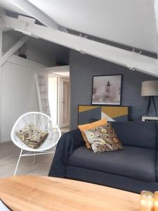 uma sala de estar com um sofá azul e uma cadeira em Le DUPLEX de Boulogne/Roland Garros/1 à 4 personnes em Boulogne-Billancourt