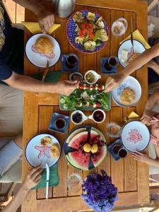 een groep mensen die rond een tafel zitten met eten bij Izgen Bungalows in Cıralı