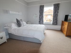 a bedroom with a bed and a television and a window at Anglesey House in Nantwich