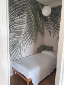 a bedroom with a bed with a palm leaf mural at Appartamento con vista lago in Toscolano Maderno
