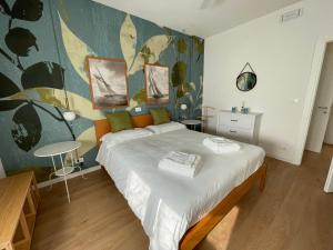 a bedroom with a large bed and a painting on the wall at Appartamento con vista lago in Toscolano Maderno