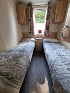 2 Betten in einem kleinen Zimmer in einem Wohnwagen in der Unterkunft Stunning modern lodge in Port Seton
