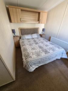 ein Schlafzimmer mit einem großen Bett in einem Zimmer in der Unterkunft Stunning modern lodge in Port Seton