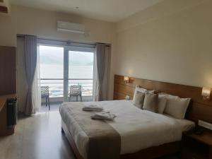 a bedroom with a large bed with a large window at Urban Boutique Hotel Pokhara in Pokhara