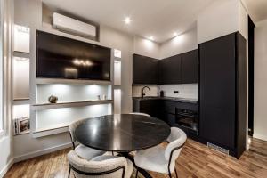 a dining room with a table and chairs and a kitchen at Les Jacobins, hypercentre in Lyon +24 photos