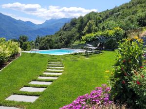 a garden with a swimming pool and some flowers at PARADISE VILLA VISTA LAGO DI COMO A MENAGGIO in Menaggio