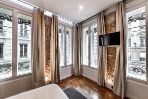 a living room with windows and a couch at Les Jacobins, hypercentre in Lyon