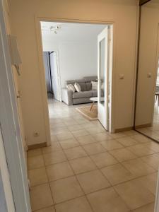 a living room with a couch and a tile floor at Appartement sans mauvaise surprises (2) in Juan-les-Pins