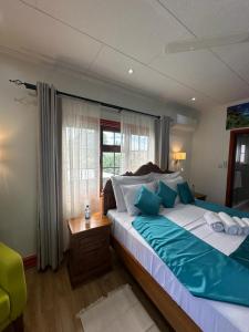 um quarto com uma cama grande e uma janela em Benjamine's Guesthouse em La Digue