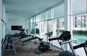 a gym with several treadmills and a swimming pool at "500m from Beach Modern Residence" in Hua Hin
