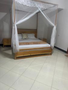 a bed with a canopy in a room at Winnie's Home in Morogoro