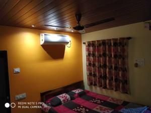 Televízia a/alebo spoločenská miestnosť v ubytovaní Guruprasad Homestay