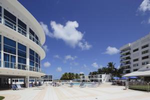 a view of a building with a pool and chairs at New Point Miami Beach Apartments in Miami Beach