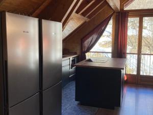 a kitchen with a stainless steel refrigerator and a counter at Chalet Valloire, 6 pièces, 12 personnes - FR-1-263-156 in Valloire