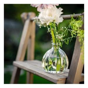 eine Vase voller Blumen auf einem Holzstuhl in der Unterkunft Maison d'une chambre avec jardin clos et wifi a Fesches le Chatel in Fesches-le-Châtel