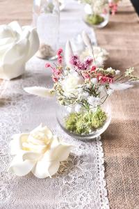 einen Tisch mit Blumen in einer Glasschüssel auf einem Tisch in der Unterkunft Maison d'une chambre avec jardin clos et wifi a Fesches le Chatel in Fesches-le-Châtel