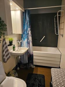 La salle de bains est pourvue d'un lavabo, de toilettes et d'une baignoire. dans l'établissement Miller Apartment - Free parking, airport 21min, à Klaukkala