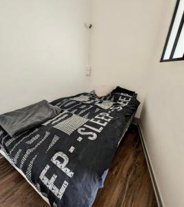 a bedroom with a bed with a black and white comforter at Excellent T2 - 5min Gare & HyperCentre in Grenoble