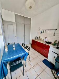 uma cozinha com uma mesa azul e cadeiras num quarto em Excellent T2 - 5min Gare & HyperCentre em Grenoble