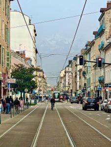 uma movimentada rua da cidade com carros e um autocarro em Excellent T2 - 5min Gare & HyperCentre em Grenoble