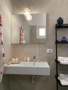 a bathroom with a white sink and a mirror at Casa Vacanze VerbaMaris in Portopalo