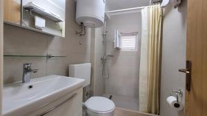 a bathroom with a sink and a toilet and a shower at Guest House Korunić in Korčula