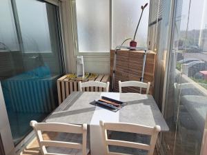 mesa y sillas en una habitación con ventana en Appartement T2 à 300m de la mer, en Palavas-les-Flots