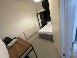 Kleines Zimmer mit einem Bett und einem Tisch in der Unterkunft 2 Bed Maisonette with free parking. South Norwood in Norwood