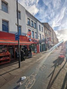 an empty city street with buildings and a street sign at Stepney Green Self Contained Studio in London