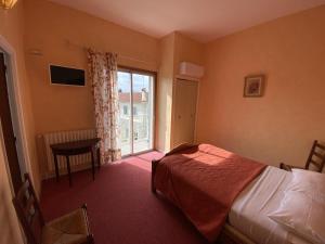 una camera con letto, finestra e tavolo di HOTEL LE FLOREAL a Le Soler