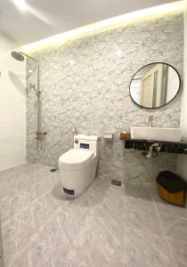 bagno con servizi igienici, lavandino e specchio di VND Vũng Tàu Hotel & Villa a Vung Tau