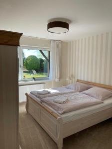 a bedroom with a large bed with a window at Haus-Seeschwalbe in Nieblum