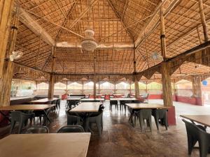 a restaurant with tables and chairs in a large room at Zestin Hill Resort Lonavala in Lonavala
