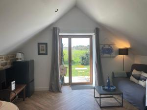 a living room with a couch and a sliding glass door at Gîtes d'Izel n°2 in Ploemel