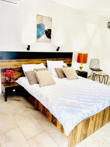 Cette chambre comprend un grand lit avec des draps et des oreillers blancs. dans l'établissement Hotel Lagadin, à Ohrid