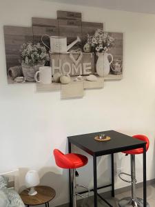 a black table and two red stools in a room at Jolie perle in Saint-Priest