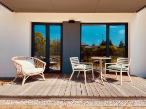 una terraza con sillas, una mesa y una mesa con sillas en 500m Sea, Terrace - Sunny Calm Coastal Retreat en Dźwirzyno