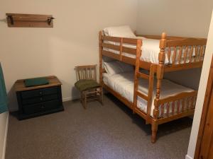 a bedroom with two bunk beds and a table at L and A Lodges in Port Talbot