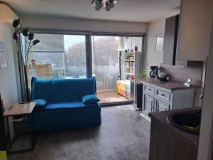 una cocina con un sofá azul en el medio de una habitación en Appartement T2 à 300m de la mer, en Palavas-les-Flots
