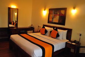 康提的住宿－The Spring Villas，酒店客房配有一张带橙色枕头的大床