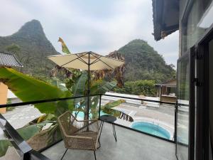 a patio with a chair and an umbrella and a pool at Yangshuo Vivian Villa in Yangshuo