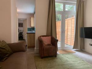 a living room with a couch and a chair and a sliding glass door at Central 2 bed flat with off street-parking in Bristol