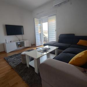 uma sala de estar com um sofá e uma mesa em Apartman Ena em Bileća