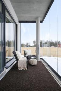 a large room with glass windows and a couch and chairs at LadyCrane apartment, sauna and parking in Kirkkonummi