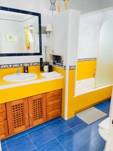 een gele badkamer met een wastafel en een spiegel bij Sweet Atic in Sitges