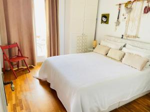 a white bed in a room with a red chair at Sweet Atic in Sitges