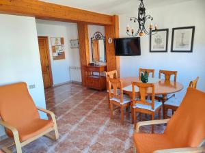 ein Esszimmer mit einem Tisch, Stühlen und einem TV in der Unterkunft Casa Burgués in Beceite