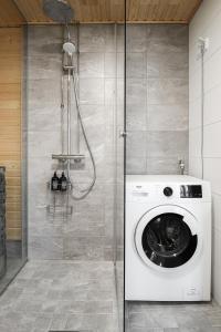 y baño con ducha y lavadora. en LadyCrane apartment, sauna and parking en Kirkkonummi